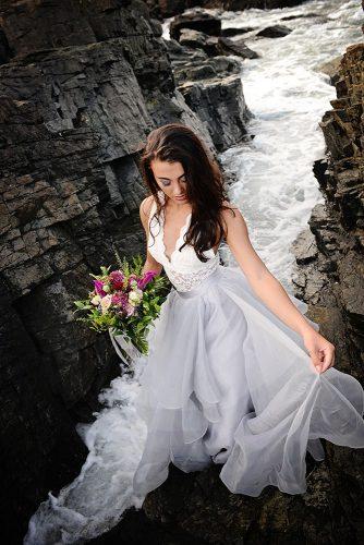 beach styled shoot bride with loose medium hair on the rocks above the sea alexi
