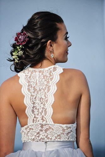 beach styled shoot lace back of dress wedding updo with flowers on dark hair alexi