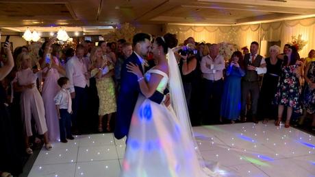 the bride and groom enjoy a slow and romantic dance on their sparkling white dancefloor in front of guests during their wedding reception at Thornton Hall hotel and spa in the wirral