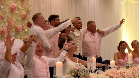 the bridal party are standing and swaying to Sweet Caroline after the wedding speeches at thornton hall