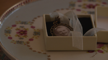 an old black and white photo of the brides nan is in a silver locket ready to hang on the brides wedding bouquet