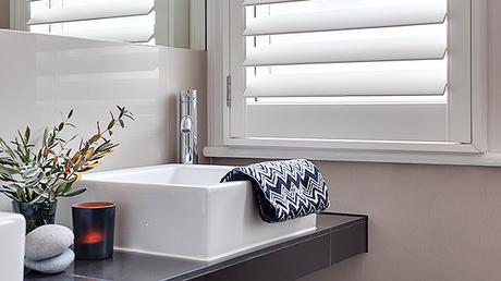 single window bathroom vanity plantation style shutters natural light
