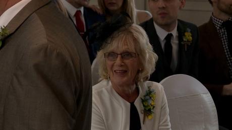 the mother of the bride sits and waits for her daughter and laughs along with the groomsmen before the wedding ceremony at Alma Lodge