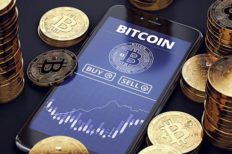 Smartphone with Bitcoin chart on-screen among piles of Bitcoins. Bitcoin trading concept. 3D rendering