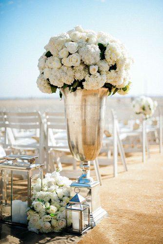 wedding trends 2019 tall elegant silver vase and lanterns with white flowers decorated the aisle yvette roman photography