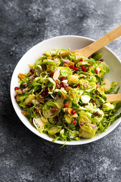 brussels sprouts salad in bowl with wooden spoons