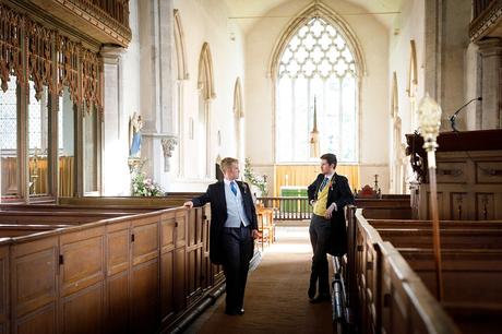 the groom and his best man chat inside dennington church