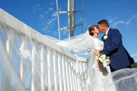 bride and groom kiss on the balcony of cley windmill