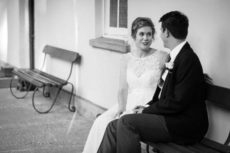 bride and groom sitting at the front of pennard house