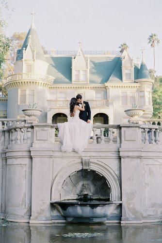 besame wedding styled shoot bride in a dress with train and bridegroom in front of an italian castle above the fountain carrie king photographer