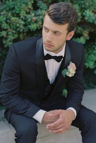 besame wedding styled shoot groom with a butterfly in a black suit with a boutonniere of roses carrie king photographer