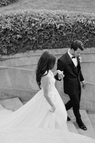 besame wedding styled shoot black white photography the groom leads the bride down the steps carrie king photographer
