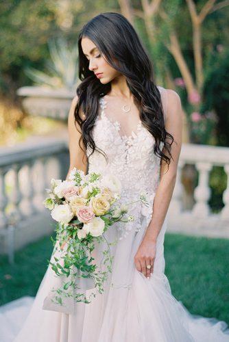 besame wedding styled shoot bride with dark loose curls in lace dress with cascading peach pink white roses bouquet with carrie king photographer