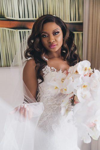 real wedding photography black bride makeup with long lashes pink lips loose curls lace dress white orchid bouquet stanlo photography