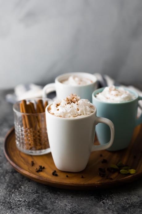 chai tea latte in coffee mugs on wooden serving tray
