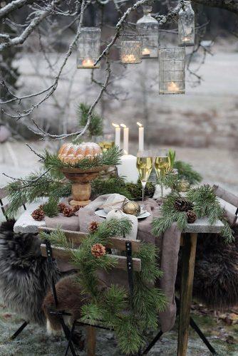 christmas wedding cozy outdoor table with pine branches hanging candles tgd