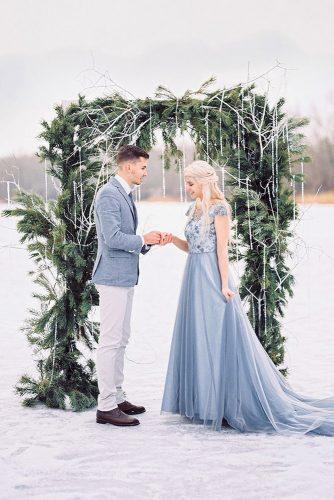 christmas wedding outdoor ceremony arch pine branches decor with white beads garlands maximdevyatkov