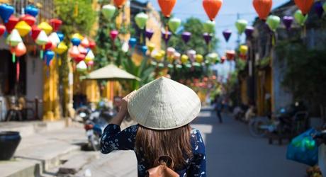 Enchanting Travels Vietnam Tours Hoi An Tourist woman is wearing Non La