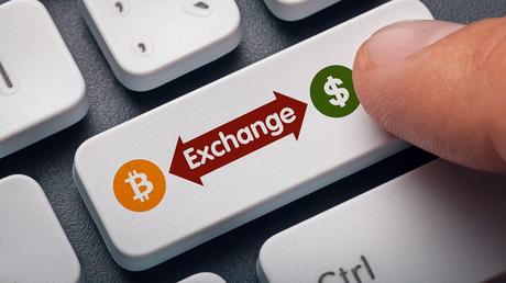 finger pressing computer key with bitcoin, dollar symbol and exchange word. crypto mining concept
