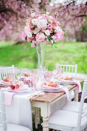 spring wedding decor tall flower centerpiece in glass vace with pink peonies caroline ross photography