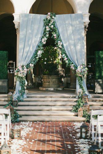 silver sage wedding ceremony arch with cloth and flower greenery onelove photography
