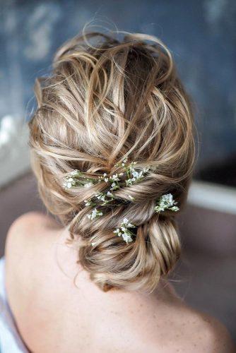 bohemian wedding hairstyles slightly messy swept low bun with fresh white flowers and greenery tanyaborisovacom