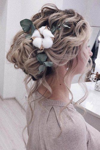 bohemian wedding hairstyles volume high bun with loose blond curls and cotton flowers makeupditt