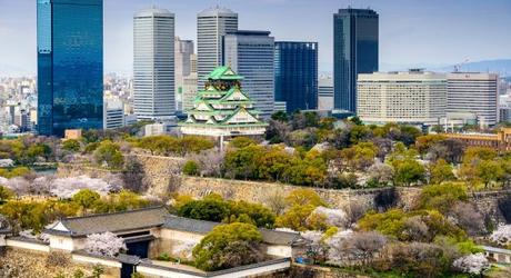 Enchanting Travels Japan Tours Osaka Japan city skyline at the castle and business park in the spring.