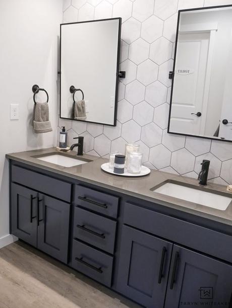 double sink bathroom vanity with dark blue cabinets and matte black handles