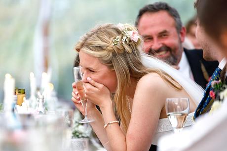 the bride laughs during the speeches of a suffolk wedding