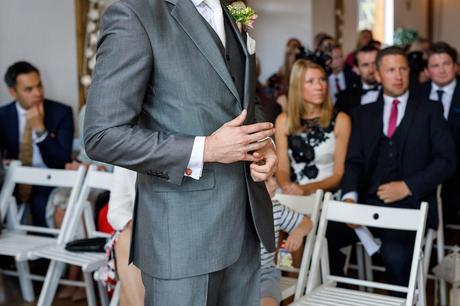 a groom waits nervously at a maidens barn wedding