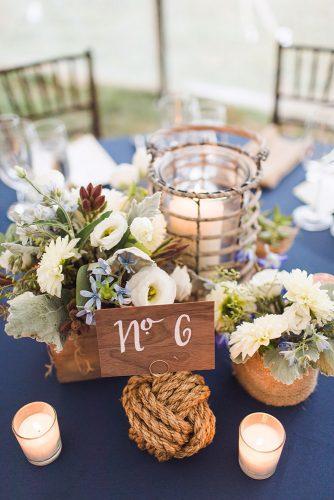 nautical wedding centerpiece with candles and flowers wooden tablenumber ashley caroline photography
