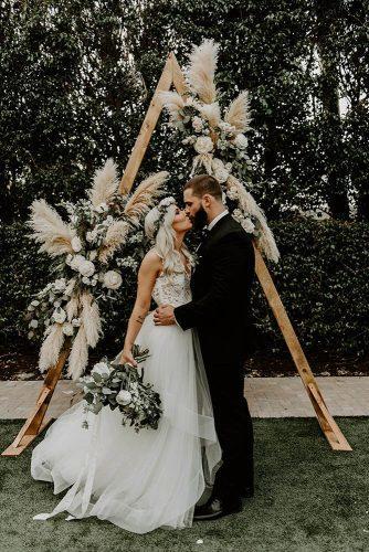 bohemian wedding decorations wooden triangle arch with pampas grass and greenery ashtyn brooke photo