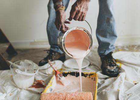 man decorating house with pink paint