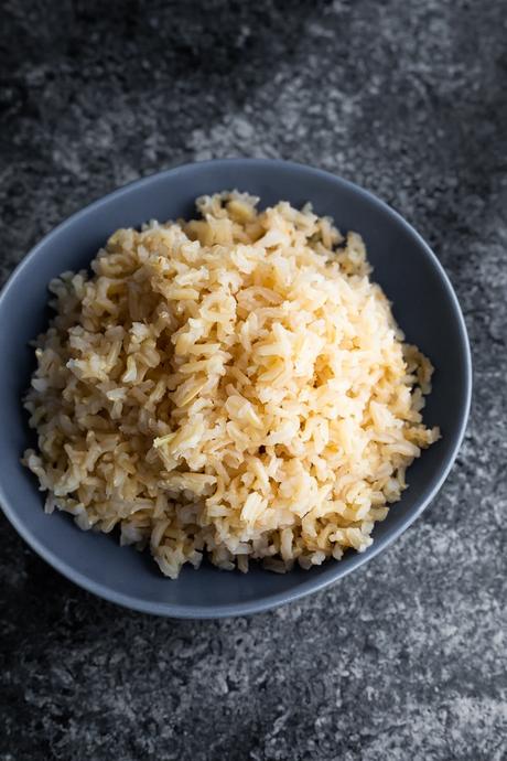 how to cook brown rice- showing cooked brown rice in blue bowl