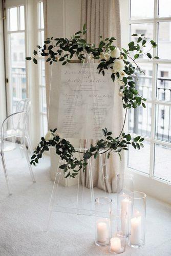 minimalist wedding decor acrylic stand with white sign decorated with greenery emily blumberg photography