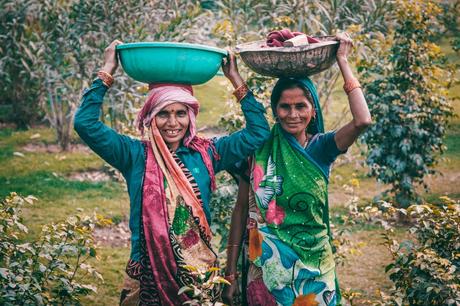Two Women Wearing Traditional Dress Carrying Basins