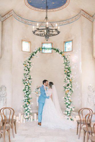 natural wedding décor indoor ceremony wih greenery flowers and candles laurenfair