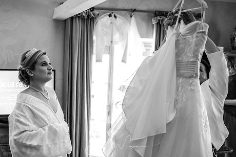 Bride looking at her hanging dress
