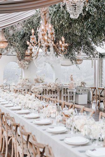 modern wedding decor ideas elegant all white reception under tent with hanging greenery siempreweddings