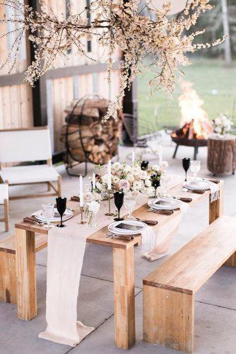modern wedding decor ideas outdoor wooden table with pink table runner and hanging florals matthewlandstudios