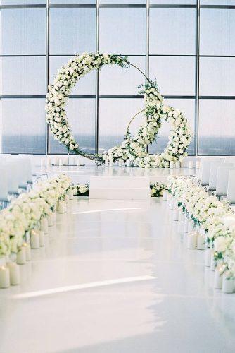 modern wedding decor ideas all white ceremony with greenery and round shaped altar spostophoto