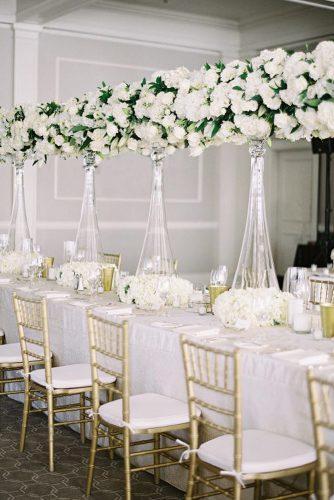 modern wedding decor ideas simple white table with tall glass centerpieces flowers and greenery spostophoto