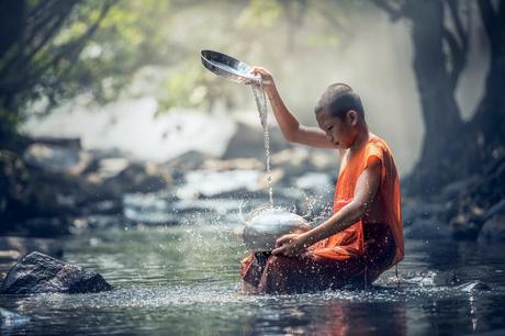 Monk Washing Dishes on River
