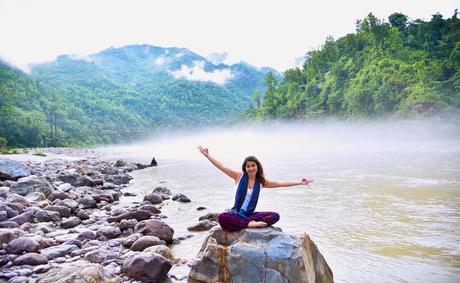 Photo of Woman Sitting on Stone Next to Body of Water