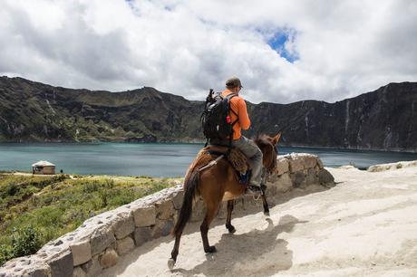 Man carrying a bag pack Riding a Brown Horse