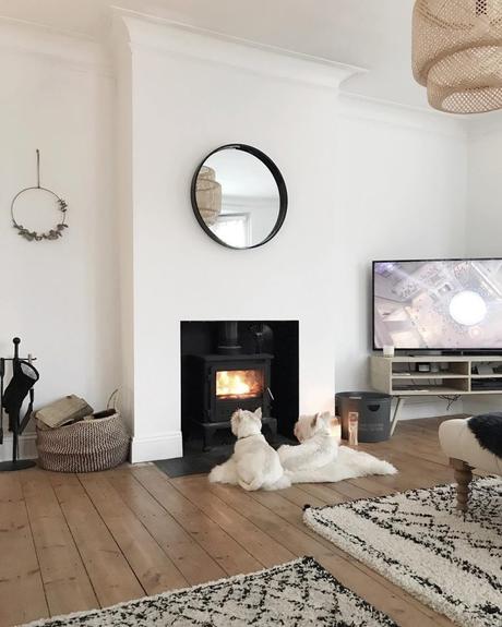 two westie dogs sat by the fire in a modern Scandinavian style home