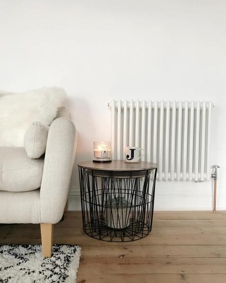 Scandinavian style chair, side table and white column radiator on a white wall