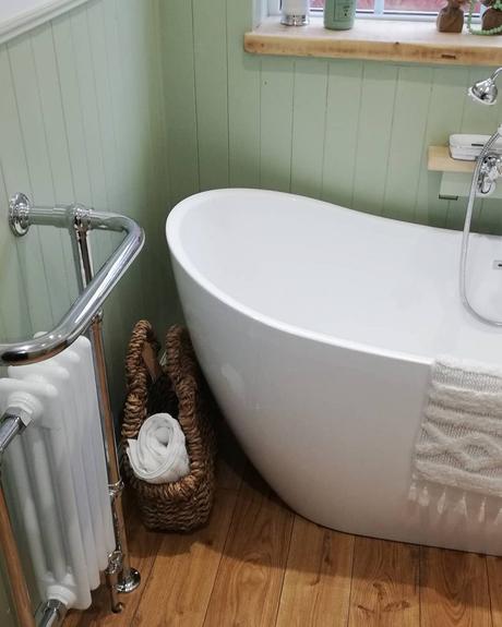 How Do You Do Comfort? a white column heated towel rail in a green bathroom