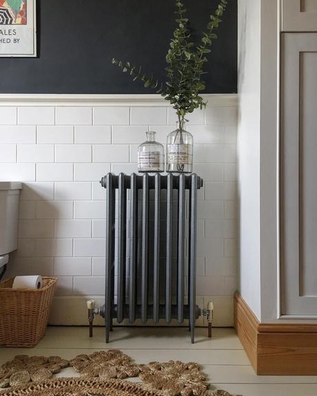 A gray cast-iron radiator on a white wall.